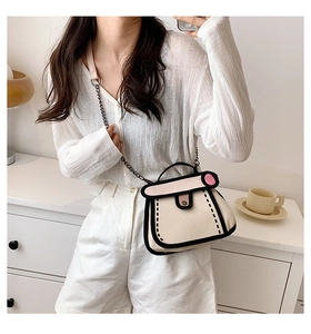 Close-up of 2D comic style canvas handbag with pink accents and metal chain strap