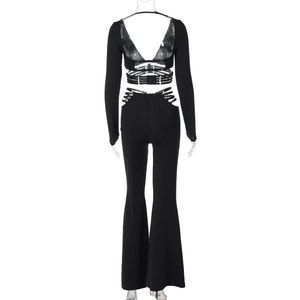Detail of back view showing cutout design on black crop top and flared trousers