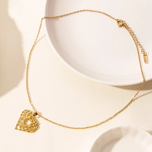 Detail of a 18k gold plated stainless steel hollow heart pendant on a thin link chain