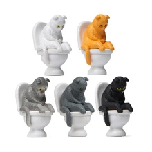 Five assorted miniature cat figurines sitting on toilets for creative desktop decoration