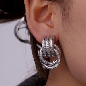 Close-up of silver spiral cable earrings with multi-ring nesting design for women
