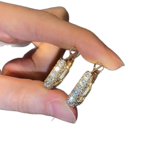 Elegance gold square hoop earrings with cubic zirconia stones shown on hand