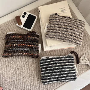 Three retro knitted zipper pouches with striped and textured patterns for small items