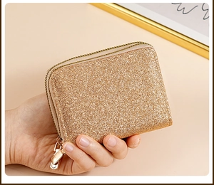 Detailed macro shot of a champagne gold glitter card holder featuring a luxury gold zipper