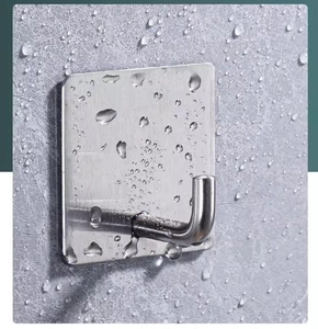 Detail of waterproof stainless steel wall hook with droplets on brushed metal surface