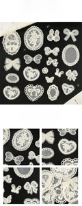 Detail view of assorted white lace embroidery patches including butterflies and flowers