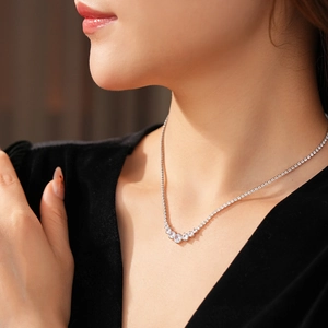 Detail view of a silver-colored tennis necklace with sparkling cubic zirconia on a model