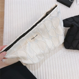 Detail of 3D embossed shell texture and simple wish label on white canvas bag