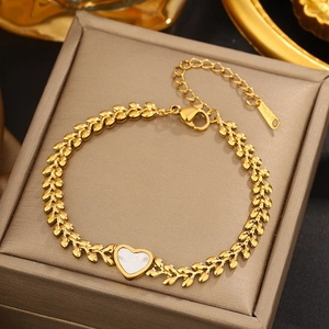 Detail of gold-plated stainless steel leaf chain bracelet with white heart shell charm