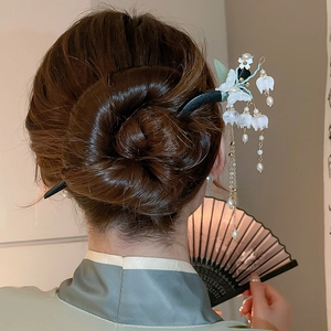 Close-up of butterfly flower hair pin with pearl tassels on a classic bun hairstyle
