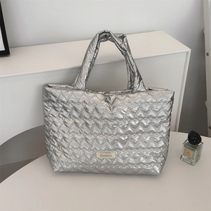 Close-up of a silver heart-quilted tote bag with high-quality metallic finish and logo
