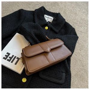 Flat lay of brown leather handbag with black tweed jacket and LIFE magazine detail
