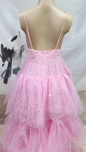 Detail of pink tiered mesh dress featuring silver star sequins and an open back design