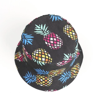 Close-up of tropical pineapple print on black canvas bucket hat with vibrant colors