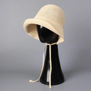 Close-up of cream knit sun hat with breathable texture and ribbon tie details