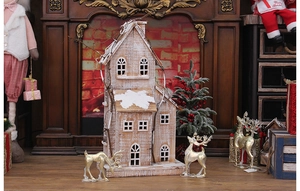 Close-up of a rustic wooden Christmas house with snow-white roof and cutout windows