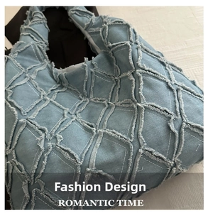Detailed macro view of light blue denim tote with frayed edges and patchwork pattern