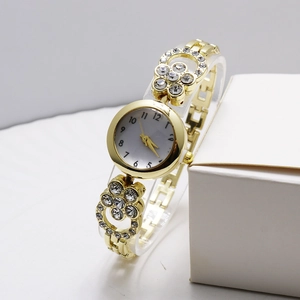 Dettaglio dell'orologio al quarzo dorato con bracciale in metallo a farfalla con strass
