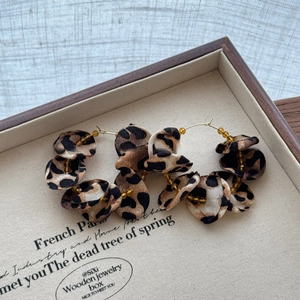 Macro view of leopard print fabric flower earrings with crystal beads and gold metal