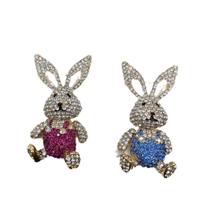 Exquisite rabbit brooches with sparkling pink and blue rhinestones on white background