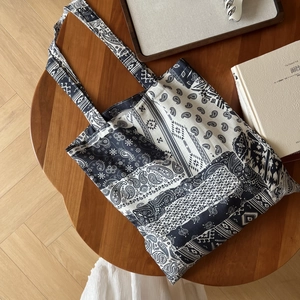Gros plan du sac cabas bohème en toile avec motifs paisley bleu marine et ethniques