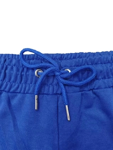 Detalle de cintura elástica azul real con cordón y ojales metálicos de pantalón deportivo