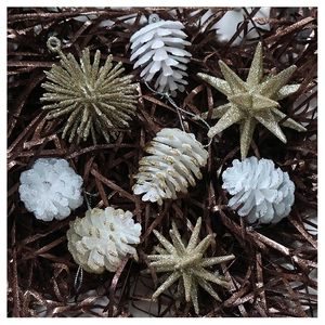 Macro detail of glitter-covered champagne gold star and white pine cone ornaments