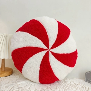 Close-up of a plush red and white peppermint candy pillow with soft fleece texture