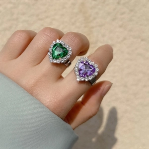 Close-up of heart-shaped emerald and amethyst rings with diamond pavé and adjustable band