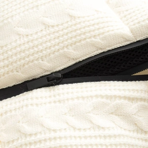 Winter off-white knit jacket featuring thick cable-knit texture and black zipper detail
