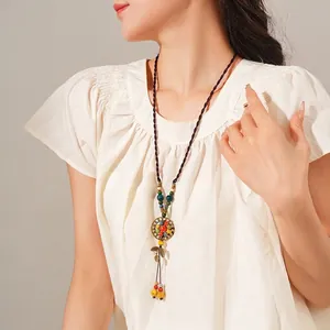 Bohemian ceramic leaf pendant necklace with colorful beads on a brown braided rope chain
