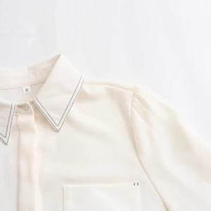Elegant off-white chiffon blouse with black contrast stitching and minimalist design