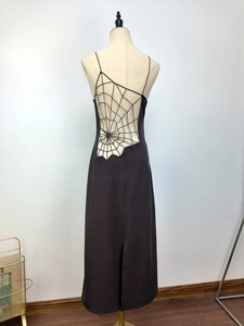 Detailed back view of a black maxi dress featuring a complex spiderweb crochet cutout design