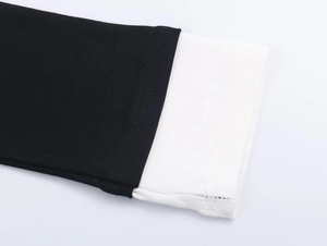 Detail view of black and white contrast ribbed knit fabric with reinforced flat seams