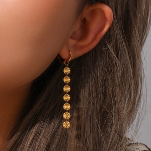 Detail of 18K gold plated stainless steel long chain snowflake tassel earrings on model