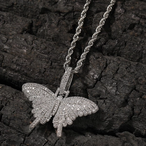 Close-up of iced out butterfly pendant with pavé cubic zirconia on twisted rope chain