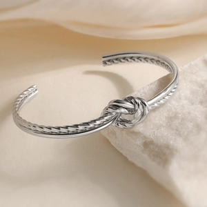 Polished silver knot cuff bracelet in geometric stainless steel with twisted rope texture