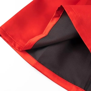 Detailed close-up of red fabric hem with black lining and premium stitched seams