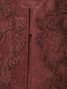 Detailed close-up of 3D floral embroidery on deep red suede fabric of the vest
