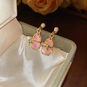 Pink resin gourd earrings with pearl and gold trim on silk in a gift box