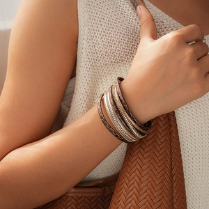 Gros plan d'un bracelet multicouche en cuir avec strass en cristal et texture en nid d'abeille