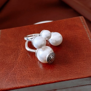 Close-up of vintage silver open ring with four pearls and Greek key engraving