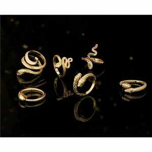 Snake shape gold rings set with colorful cubic zirconia stones on black background