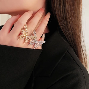 Detail of gold and silver butterfly rings with zircon and pearls on female hand