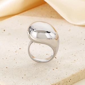 Detailansicht 18K vergoldeter dicker gebogener Ring auf beigem Stein und Goldseide
