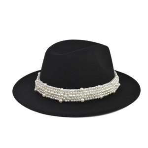 Detalle de sombrero de fieltro negro con elegante decoración de banda de perlas