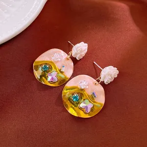 Floral butterfly crystal drop earrings with gold finish on elegant velvet background