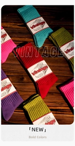 Détail de chaussettes en coton côtelé colorées avec étiquettes vintage sur bois sombre