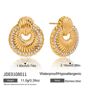 Macro detail of gold stainless steel shell texture earrings with sparkling crystal accents