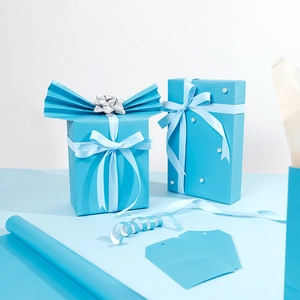 Tiffany blue gift wrapping kit with iridescent paper rolls, ribbons, and decorative pearls